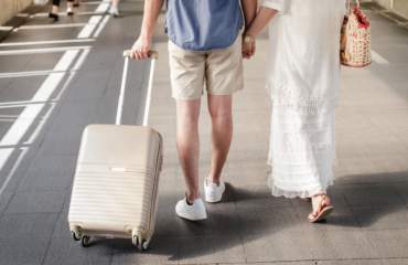 man and woman walking with suitcase