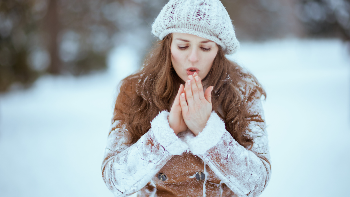 Cold woman blowing on her hands