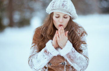 Cold woman blowing on her hands